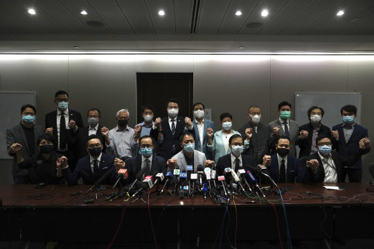 홍콩의 범민주파 입법회 의원들이 11일(현지시간) 의사당에서 기자회견을 하기 전 손을 맞잡고 포즈를 취하고 있다. 이들은 동료의원 4명이 이날 직을 박탈당하자 항의의 뜻으로 동반 사퇴하겠다고 밝혔다.      홍콩 AP=연합뉴스